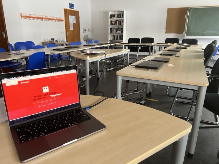 A school computer room prepared for a piloting workshop, with the UP-RES website open on a laptop in the foreground.