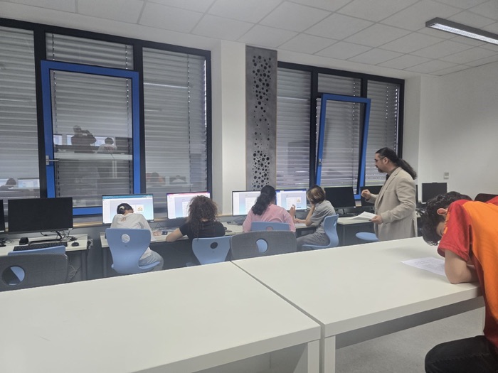 A trainer talking to students as they work through the resilience modules at their computers.