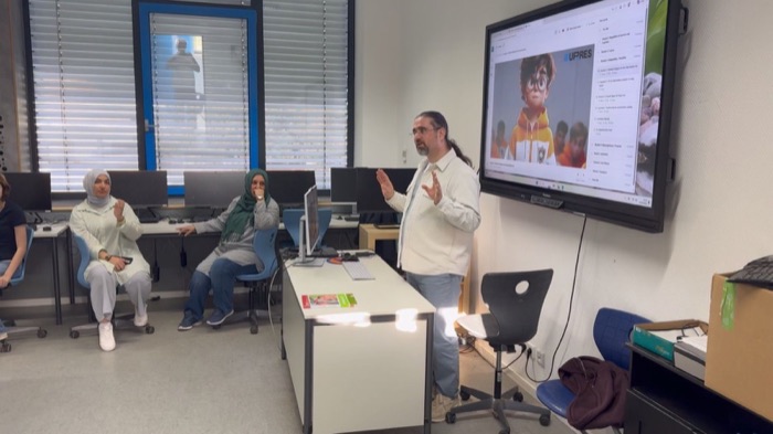 A trainer presenting a UP-RES module to participants in a computer room.